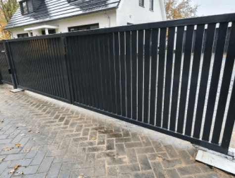 Zwarte draaipoort met ondergrondse poortopener